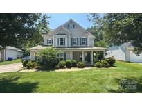 Charming two-story home with a well-manicured lawn and inviting front porch at 7731 Sedgebrook E Dr, Stanley, NC 28164