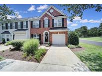 Charming brick-front townhome with well-manicured landscaping and attached garage at 918 Kite Dr, Fort Mill, SC 29715