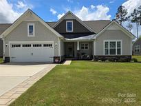 Charming single-story home features a well-maintained lawn and attached two-car garage at 1224 Dali Blvd, Mount Holly, NC 28120