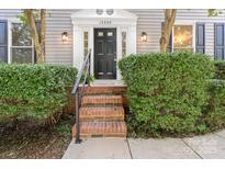 Charming home featuring a black front door, brick steps, and well-maintained landscaping at 12325 Woodside Falls Rd, Pineville, NC 28134