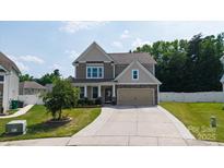 Two-story home with a two-car garage, beautiful lawn, manicured landscaping, and a long concrete driveway at 12704 Franklin Square Rd, Charlotte, NC 28213