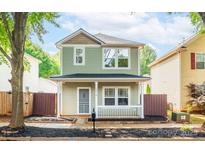 Charming two-story home features a welcoming front porch and well-maintained landscaping at 13115 Meadowmere Rd, Huntersville, NC 28078