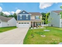 Charming two-story home with landscaped yard, attached garage and covered front porch at 154 Tanner Loop, Troutman, NC 28166