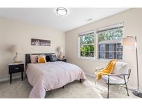 Bright bedroom featuring two windows, neutral walls, a bed, and cozy reading chair with a throw at 1620 #K Arlyn Cir # K, Charlotte, NC 28213