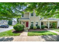 Charming townhome with a well-manicured lawn, tasteful landscaping, and covered front porch at 17729 Trolley Crossing Way, Cornelius, NC 28031