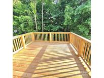 Wide shot of newly constructed wooden deck with wooden railing overlooking lush, green trees at 206 N Kayla Dr, Salisbury, NC 28146