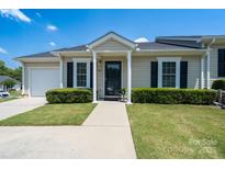Charming single story home with manicured lawn and inviting entryway, a delightful curb appeal at 407 Hertling Nw Dr, Concord, NC 28027