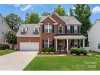 Charming two-story brick home with a well-manicured lawn and inviting front porch at 512 Veloce Trl, Fort Mill, SC 29715