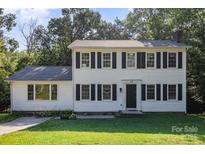 Charming two-story home featuring black shutters, a well-manicured lawn, and a welcoming front entrance at 80 Lecline Ne Cir, Concord, NC 28025