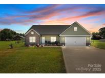 Charming single-story home features a two-car garage and a well-manicured front yard, perfect for curb appeal at 100 Royal Ave, Albemarle, NC 28001