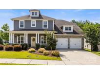 Charming two-story home with inviting front porch and well-manicured lawn, showcasing its curb appeal at 11317 Fullerton Place Nw Dr, Huntersville, NC 28078
