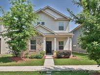 Charming two-story home featuring a blend of siding and brick, with a well-manicured lawn and sidewalk at 11807 Midnight Way, Huntersville, NC 28078