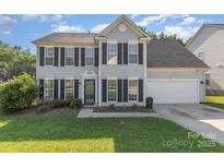 Charming two-story home with black shutters, green lawn, and attached two-car garage on a sunny day at 12250 Wallace Ridge Dr, Charlotte, NC 28269