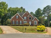 Beautiful two-story brick home with lush landscaping, black shutters and a well manicured lawn at 13101 Kensworth Ct, Charlotte, NC 28277