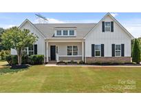 Charming single-Gathering home with a well-manicured lawn, front porch, and classic white siding at 152 Riverstone Dr, Davidson, NC 28036
