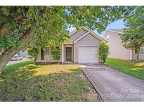 Charming one-story home featuring a single-car garage and well-maintained lawn, with a tree for shade at 1703 Southwind Dr, Charlotte, NC 28216