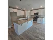 Bright kitchen with white cabinetry, stainless steel appliances, granite countertops, and a large center island with a sink at 200 N Kayla Dr, Salisbury, NC 28146