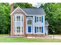 Charming two-story home with blue shutters and brick accents, set amidst lush green trees at 2014 Steeplechase Dr, Rock Hill, SC 29732