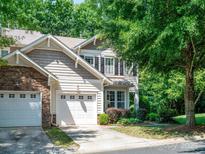 Charming two-story townhome boasts an attached two-car garage, manicured lawn and natural stone accents at 2545 Chasewater Dr, Fort Mill, SC 29707