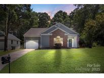 Charming single-Gathering home featuring brick facade, lush lawn, and inviting front entrance at 3212 Ashwell Oaks Ln, Matthews, NC 28105