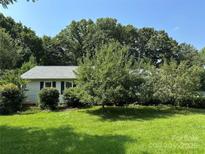 Charming single-story home with lush green lawn and mature trees offering shade and privacy at 3427 Wonderland Dr, Matthews, NC 28104