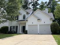 Charming two-story home featuring a two-car garage, lush lawn, and a classic white facade at 3617 Betterton Ln, Charlotte, NC 28269