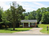 Charming one-story brick home with a manicured lawn and mature tree at 412 E Taylor St, Landis, NC 28088