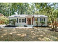 Charming single-story home featuring a white brick facade, dark shutters, and a well-manicured front yard at 4226 Raney Way, Charlotte, NC 28205