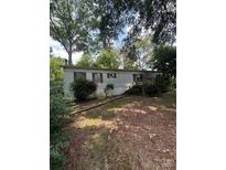 Charming single-story home with wooden stairs leading to the front door, surrounded by lush trees at 5104 Forestmont Dr, Matthews, NC 28105