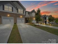 Charming townhome exterior with a two-car garage and well-maintained landscaping at 7032 Everly Commons Ln, Tega Cay, SC 29708