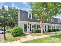 Charming townhouse featuring a well-maintained lawn and classic architectural details at 8062 Knights Bridge Rd, Charlotte, NC 28210