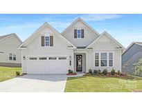 Charming home with white siding, a two-car garage, well-manicured lawn, and stylish curb appeal at 1074 Wylie Falls Ln, York, SC 29745