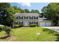 Charming two-story home with a manicured lawn, classic shutters, and an attached two-car garage at 1109 Sunnyview Cir, Matthews, NC 28105