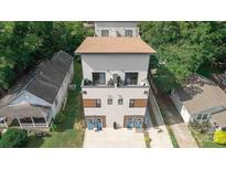 Modern duplex with light gray exterior and balcony, surrounded by lush greenery at 1113 Greenleaf Ave # A, Charlotte, NC 28202