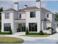 Stunning two-story home with a white brick exterior, large windows, manicured landscaping, and three prominent chimneys at 1436 Queens W Rd, Charlotte, NC 28207