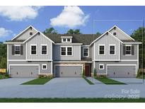 New construction townhome showing stone accents, gray siding, and two-car garages at 176 Quartz Hill Way, Waxhaw, NC 28173