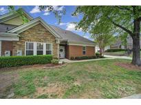 Charming home featuring a stone facade, brick accents, well-maintained lawn, and manicured landscaping at 2959 Bellasera Way, Matthews, NC 28105