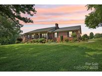 Sprawling brick ranch home with a lush, landscaped front yard and a covered front porch at 3381 Elaine Ave, Lincolnton, NC 28092