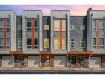 Modern townhome exterior featuring brick accents, multiple windows, and individual garages in a contemporary design at 3643 Vallette Ct, Charlotte, NC 28203