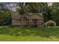Charming single-Gathering home with a welcoming front porch, mature trees, and a detached garage at 544 Hicks Creek Rd, Troutman, NC 28166