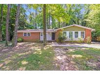 Charming single-story brick home with mature trees and a well-maintained front yard at 6513 Old Post Rd, Charlotte, NC 28212