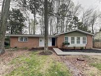Charming single-story brick home with a well-manicured lawn and mature trees, offering great curb appeal at 6513 Old Post Rd, Charlotte, NC 28212