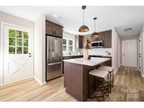 Modern kitchen featuring stainless steel appliances, an island with seating, and stylish pendant lighting at 7407 Limerick Dr, Charlotte, NC 28270