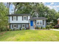Charming two-story home featuring a blue front door, updated brick facade and a well-maintained lawn at 8208 Doverdale Ln, Charlotte, NC 28217