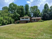 Charming two-story home with brick accents, mature trees, and a spacious front yard at 8417 Rolling Hills Ave, Hickory, NC 28602