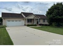 Charming ranch-style home with a well-manicured front yard and a two-car attached garage and long driveway at 1519 Midland Dr, Hudson, NC 28658