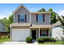 Charming two-story home with tan siding, red shutters, a garage, and a well-manicured front lawn at 437 Danielle Way, Fort Mill, SC 29715