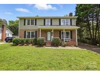 Charming two-story home with brick facade, well-manicured lawn, and inviting front porch at 6319 Welford Rd, Charlotte, NC 28211