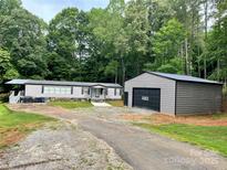 Charming home with a large garage, surrounded by lush greenery and a well-maintained driveway at 6490 Alta Ctr, Denver, NC 28037