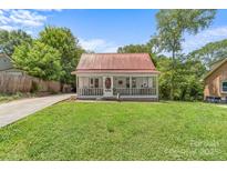 Charming single-story home with a metal roof, a screened-in porch, and a well-manicured lawn at 727 W Main Street Ext, Lincolnton, NC 28092